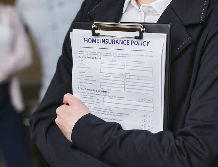 Personne consultant un contrat d'assurance habitation avec une maison protégée